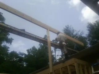 Carpenter setting a ridge beam over a new addition frame — Ice Dam Removal by Roofing Brothers in Weeping Water