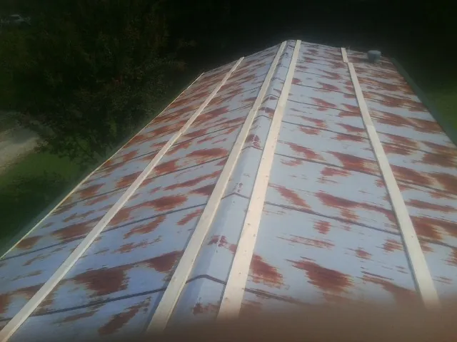 Rusted metal roof panels with new wood purlins before replacement — Storm Damage Roof Repair in Weeping Water by Roofing Brothers