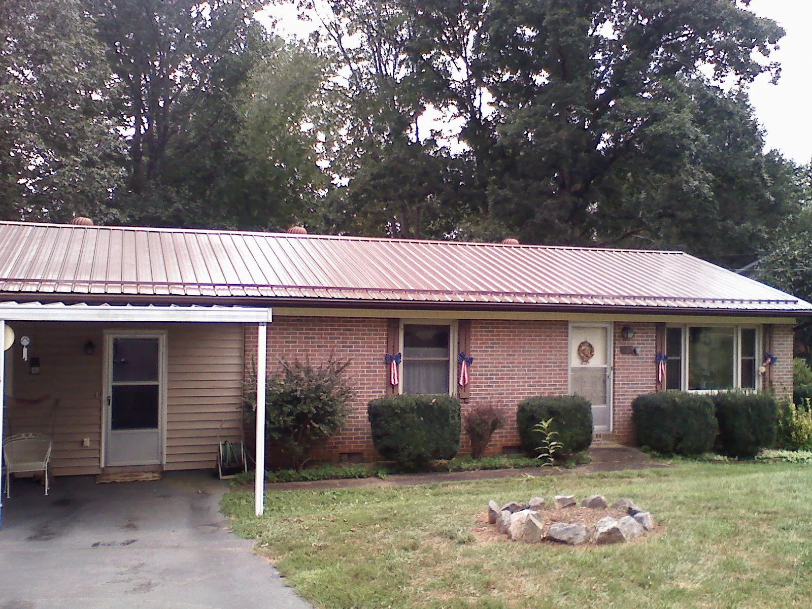 Bronze metal roof and carport on a brick ranch home — Roof Repair work by our crew in Weeping Water